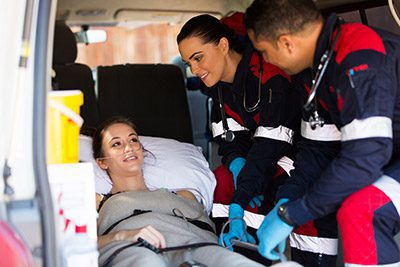 woman in ambulance using a seat belt guard to prevent her from moving while in transit.