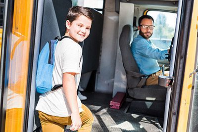 child safely getting on a bus that will use a seat belt guard to keep him safe.