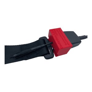 A black seat belt fastener with a red seat belt guard. A seat belt strap runs through the device.