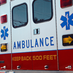 Close-up of the side panel of an ambulance, showing details such as the word 'AMBULANCE' in bold blue letters.