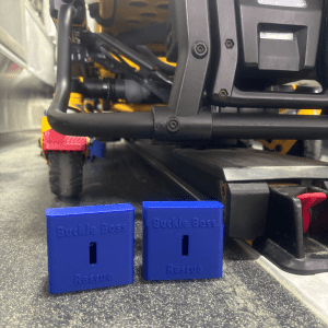 Close-up view of two blue 'Buckle Boss Rescue' devices placed on a metal surface in an emergency vehicle.