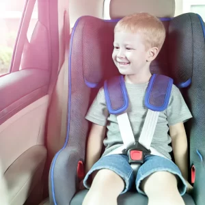 An-older-child-sitting-in-a-car-seat-using-a-5-point-harness.-The-child-looks-happy-and-comfortable-and-the-car-seat-is-securely-installed-in-the-back